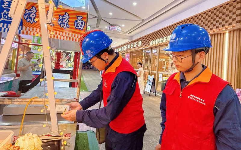 国网湖北电力员工对夜市摊位临时线路、插排设备进行细致排查。江钰潇摄