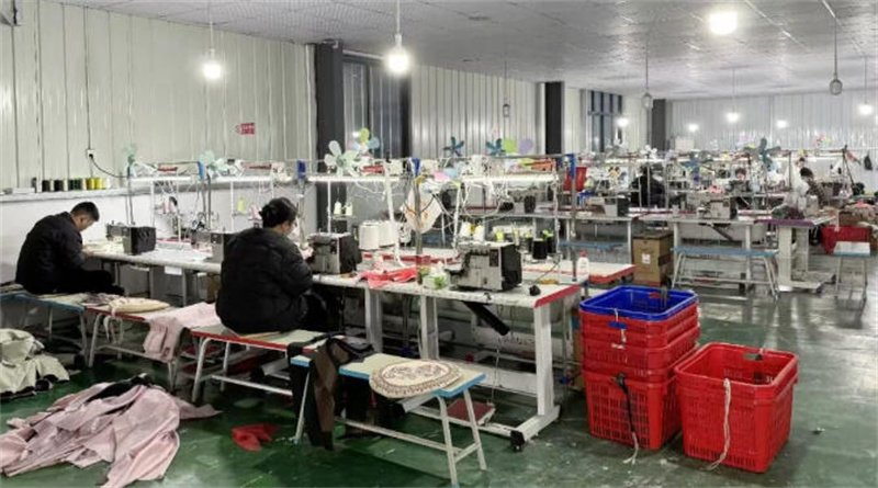 长湾社区服装企业车间里，工人们在缝纫机前忙碌。天门市委宣传部供图