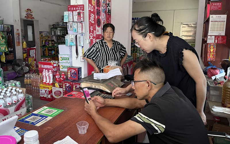 客户经理(右1)指导零售户参与法律法规知识竞赛。