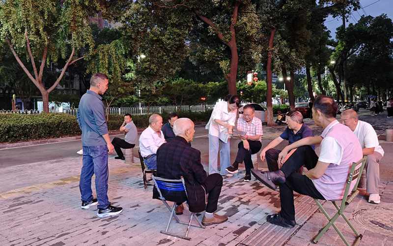 普法志愿者(右5)与社区群众围坐。